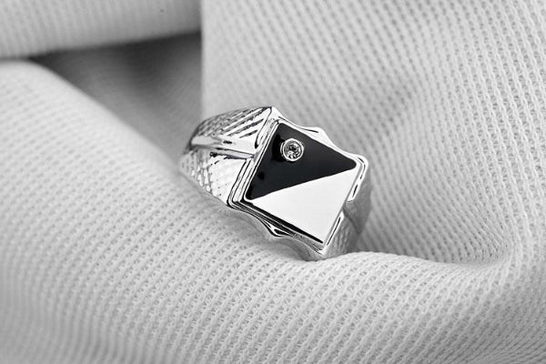 Schwarz-weißer Ring am kleinen Finger